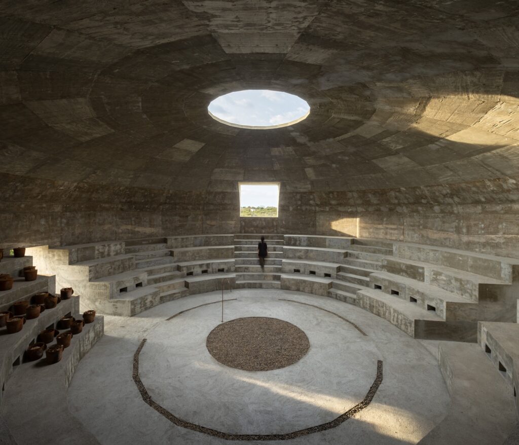Interior of the Mushroom Pavilion featuring terraced seating for clay pots, a central oculus, and a panoptic viewing experience.
