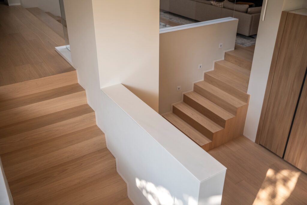 Detail of wooden staircases in House of Porous showing the transition between different floor levels and materials.