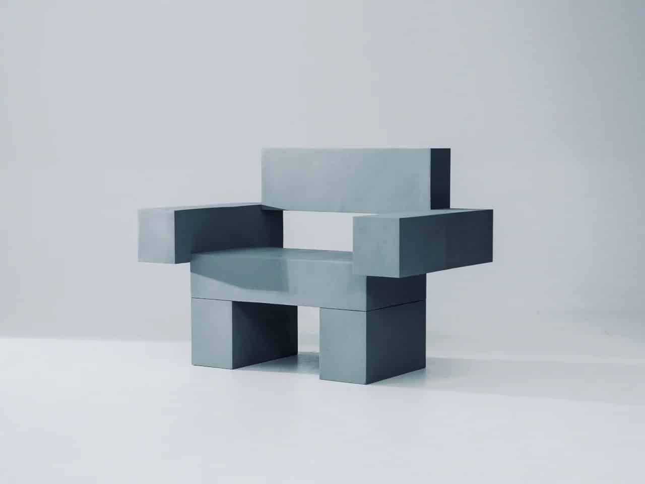 Front view of THE OBJECT 01, a grey 3D-printed brutalist chair with a modular architectural design in a white studio.