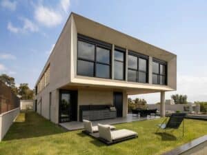 Back view of GM House showing a cantilevered concrete upper floor and an outdoor kitchen area.