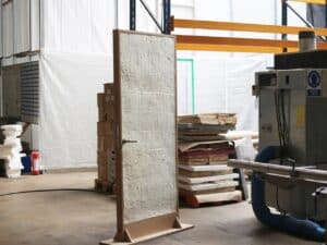 Full view of the mycelium interior door prototype in a workshop setting, showing the hybrid mycelium and timber construction.