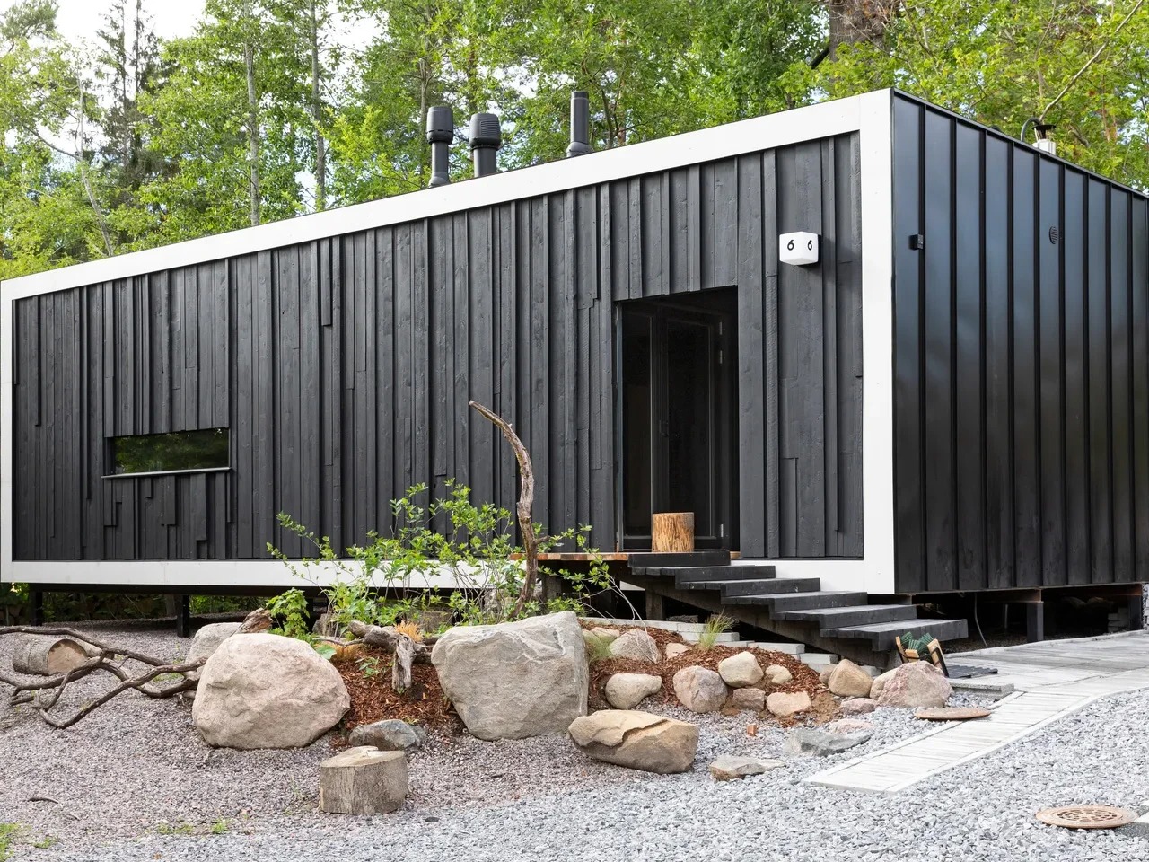 Exterior view of Tiny House Shadow by Matti Kuittinen in Lohja Finland featuring a matte black facade and recycled materials.