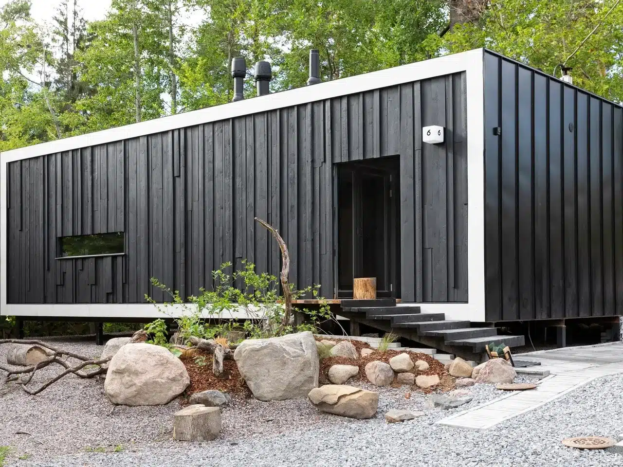 Exterior view of Tiny House Shadow by Matti Kuittinen in Lohja Finland featuring a matte black facade and recycled materials.