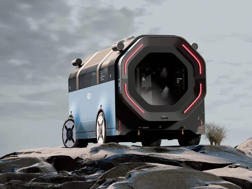 Low angle view of the HYTTE mobile home on a snowy or rocky landscape under a cloudy sky.