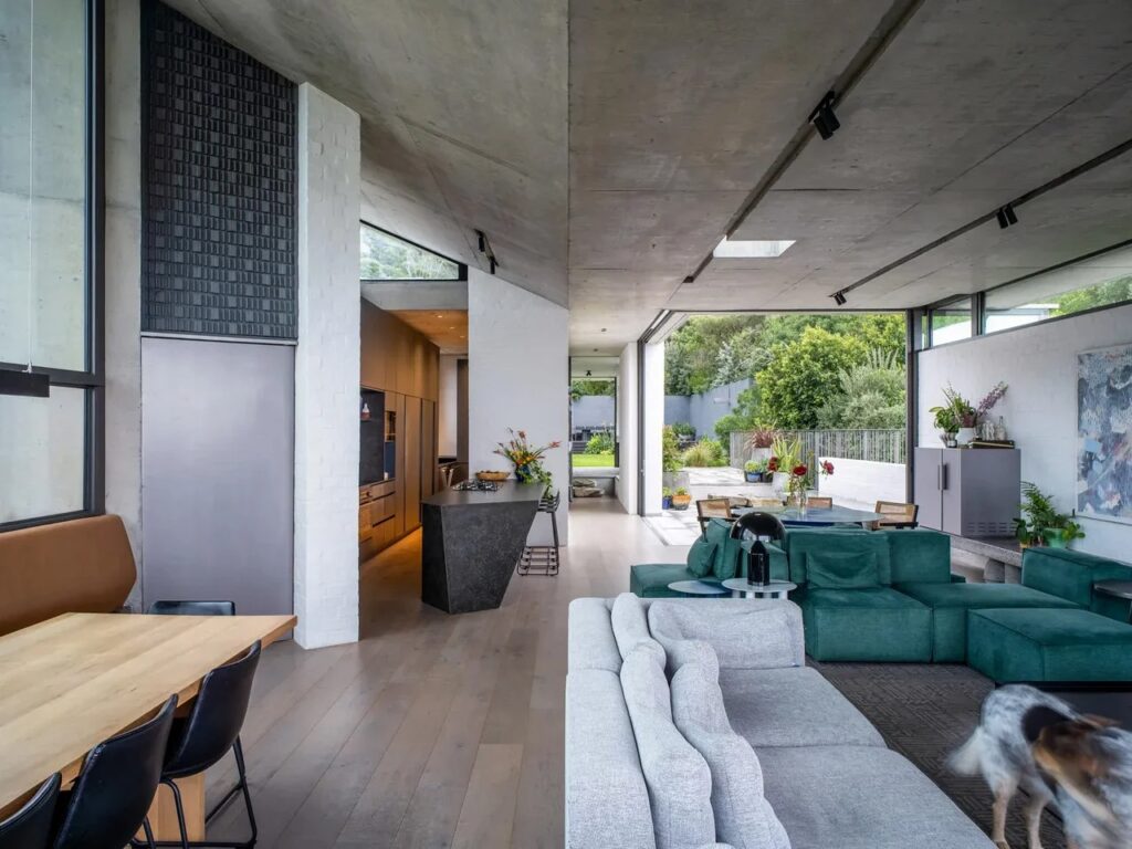 Interior perspective of Kenmore House showing a seamless transition between the living area, kitchen, and an outdoor terrace.