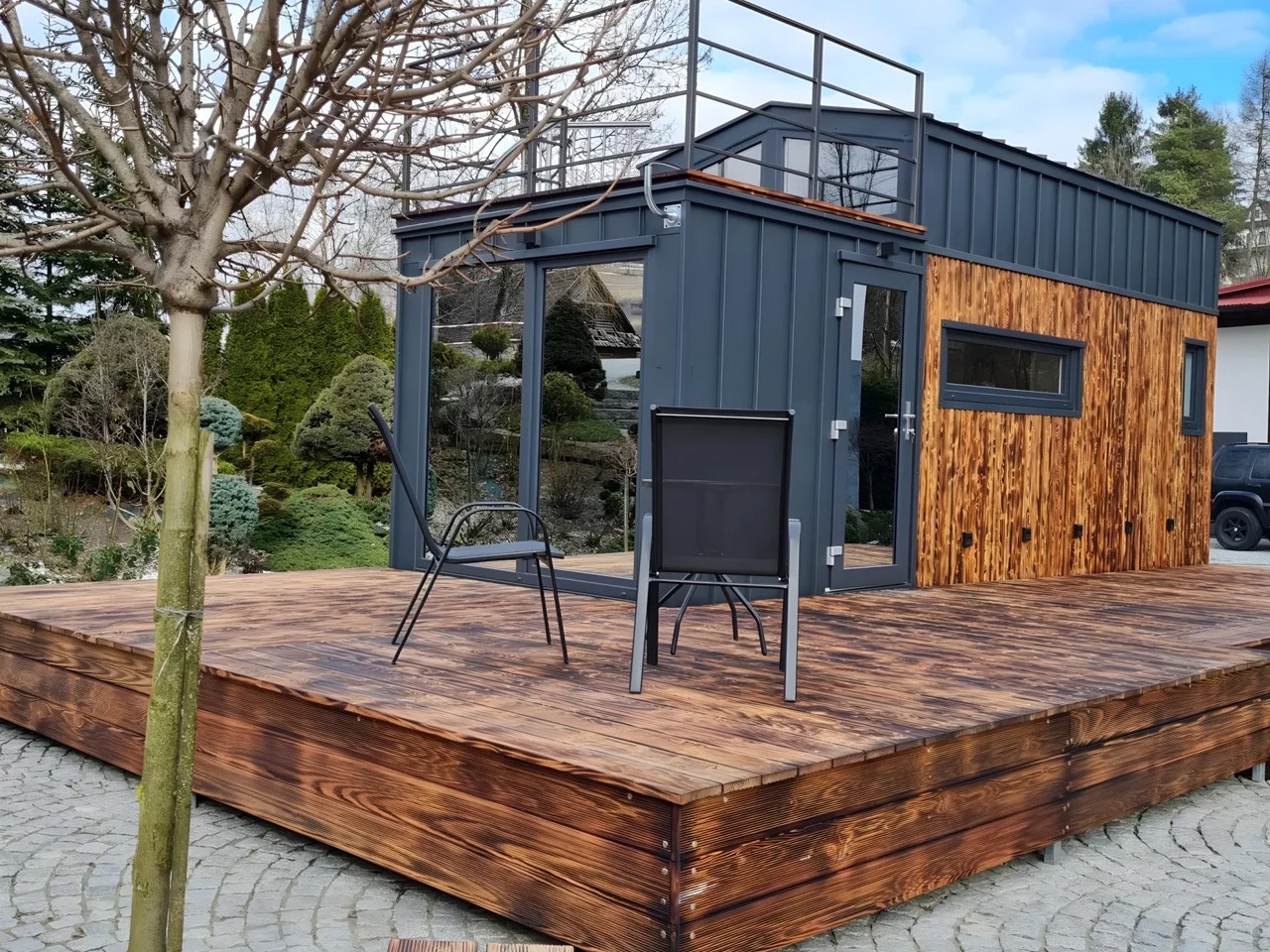 Exterior view of Erica tiny house by Craft House featuring a wooden deck and rooftop terrace.