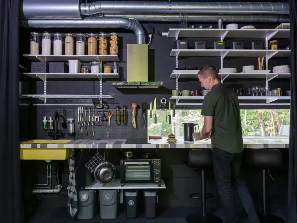 Sustainable minimalist kitchen in Tiny House Shadow with open shelving and recycled steel elements.