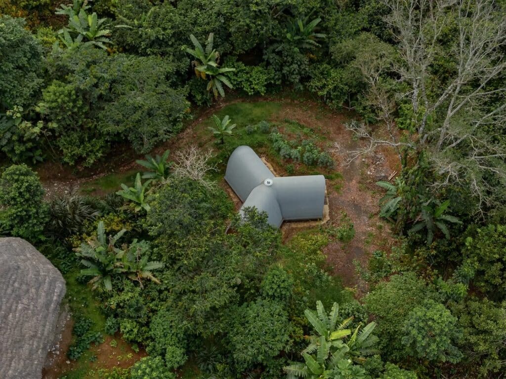 High-angle drone shot of Witocha Lab nestled deep within the lush green canopy of the Amazon rainforest in Ecuador.