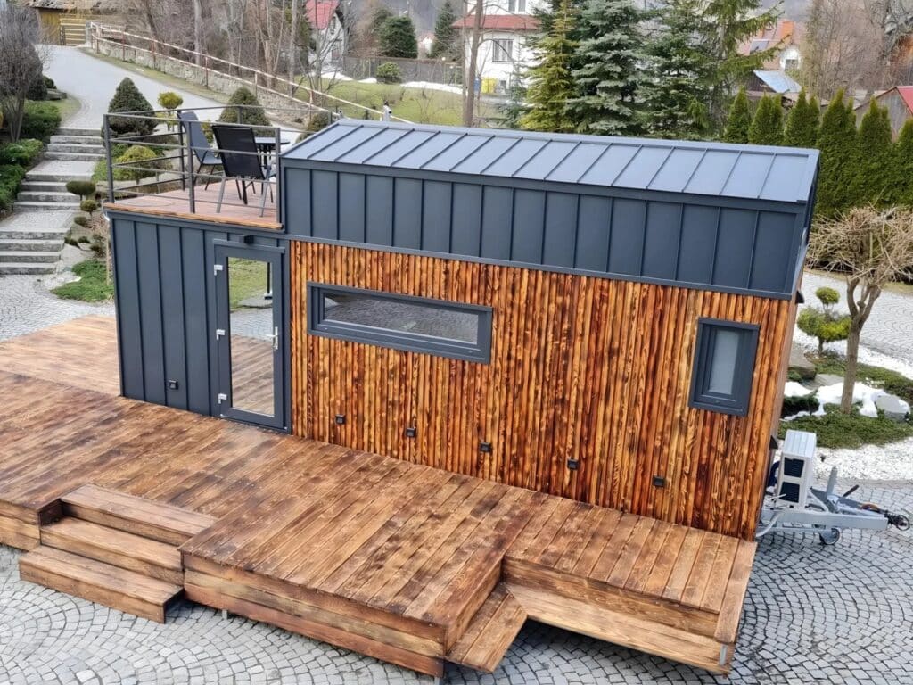 Aerial view of the Erica tiny house on wheels showcasing the rooftop terrace and metal roofing.
