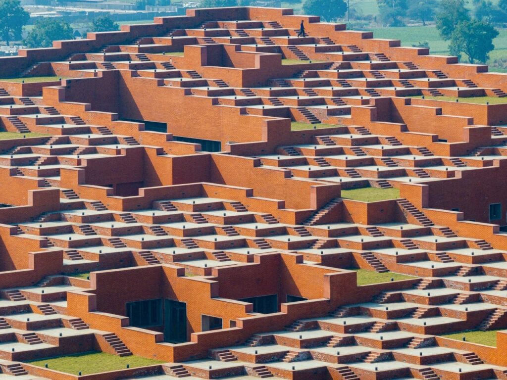 Detailed view of the repetitive geometric brick platforms and outdoor seating areas on the roof.