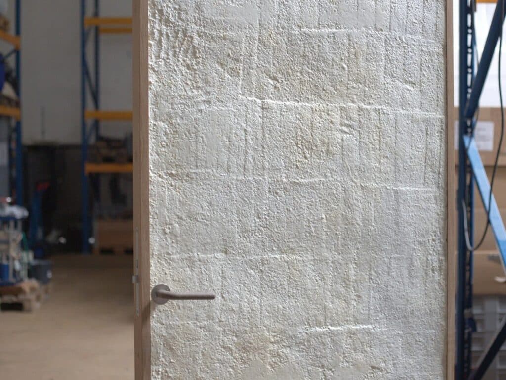 Detailed texture of a white mycelium biocomposite panel within a reclaimed wooden frame.