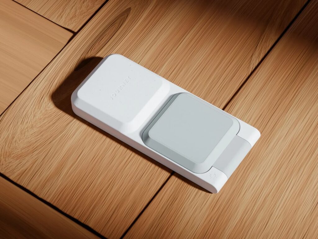 Top-down view of the ARIA 3-in-1 charger folded flat on a light wood surface, showcasing the JOURNEY branding and speckled finish.