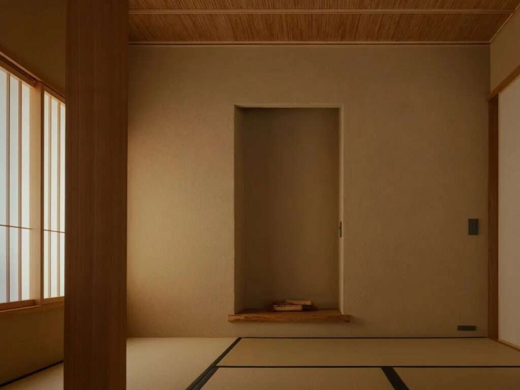 A traditional Japanese Tokonoma alcove in a tatami room with Juraku plaster walls and soft lighting.