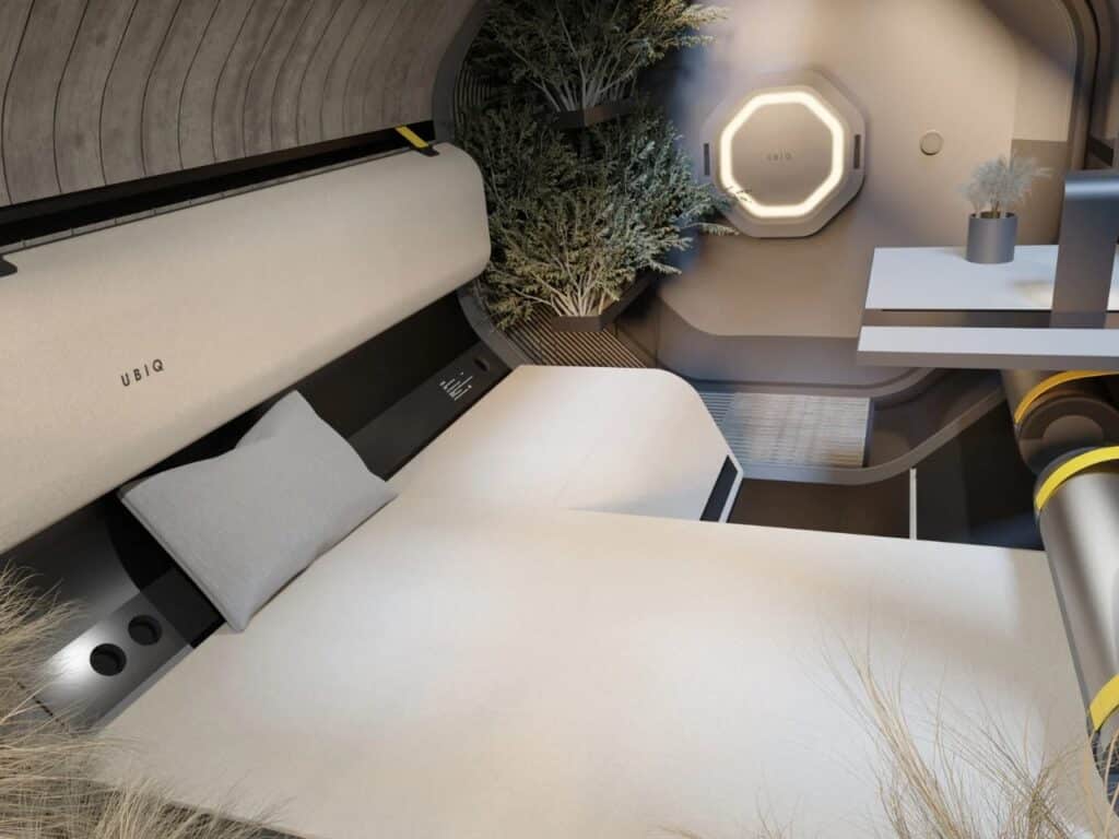 Wide shot of the HYTTE cabin interior showing the bed area, technical interface, and minimalist aesthetic.