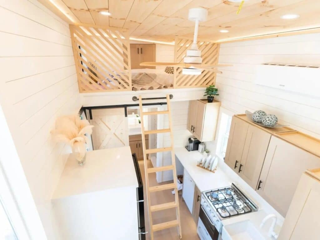 High-angle view of Premium Vista interior showing the kitchen, access ladder, and the protective loft railing.