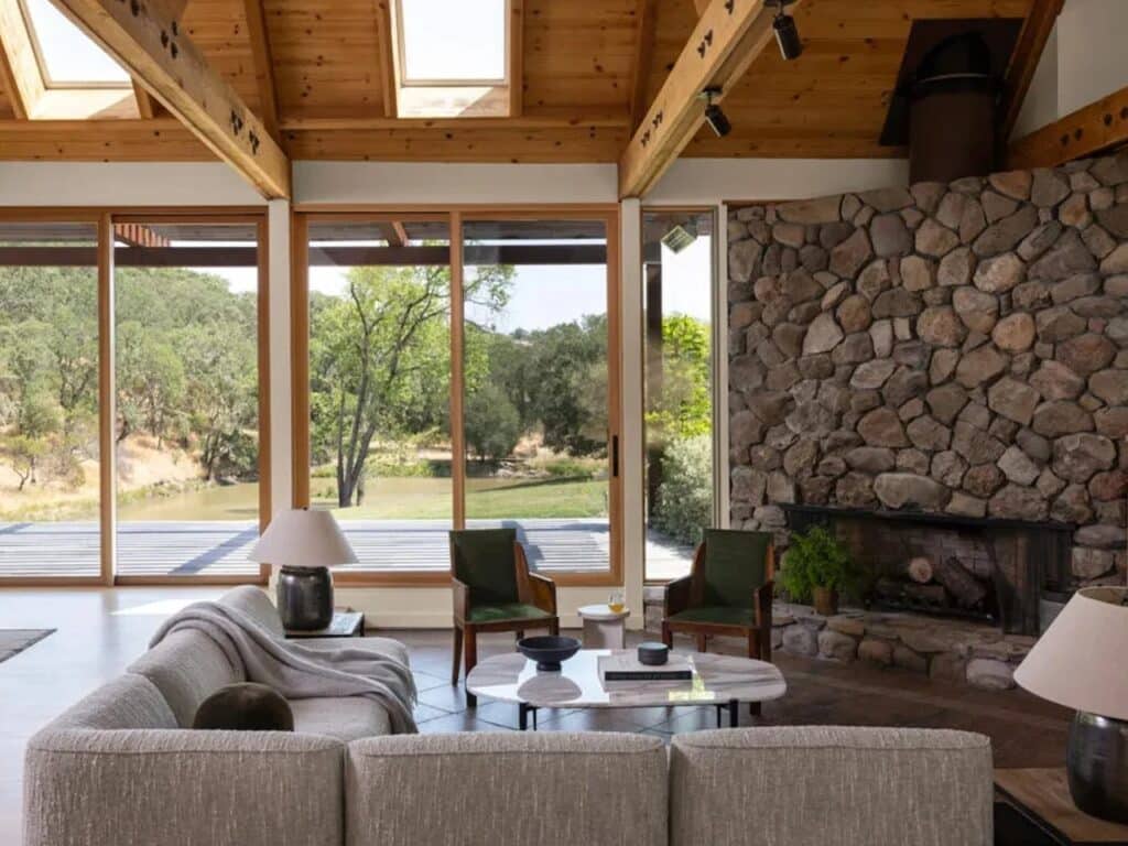 Open plan living room with a large stone fireplace and views of the Sonoma wildlife.