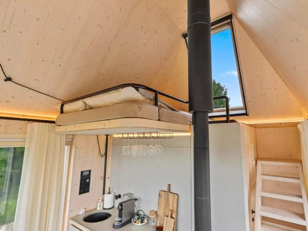 Wide interior view of Devin Cabin showing the loft bed above the kitchen and a skylight window.