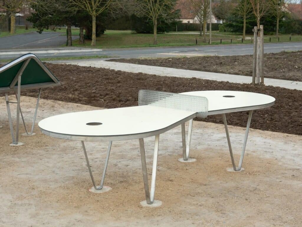 An elongated white ping-pong table with side holes, exploring the "Golf" model concept.