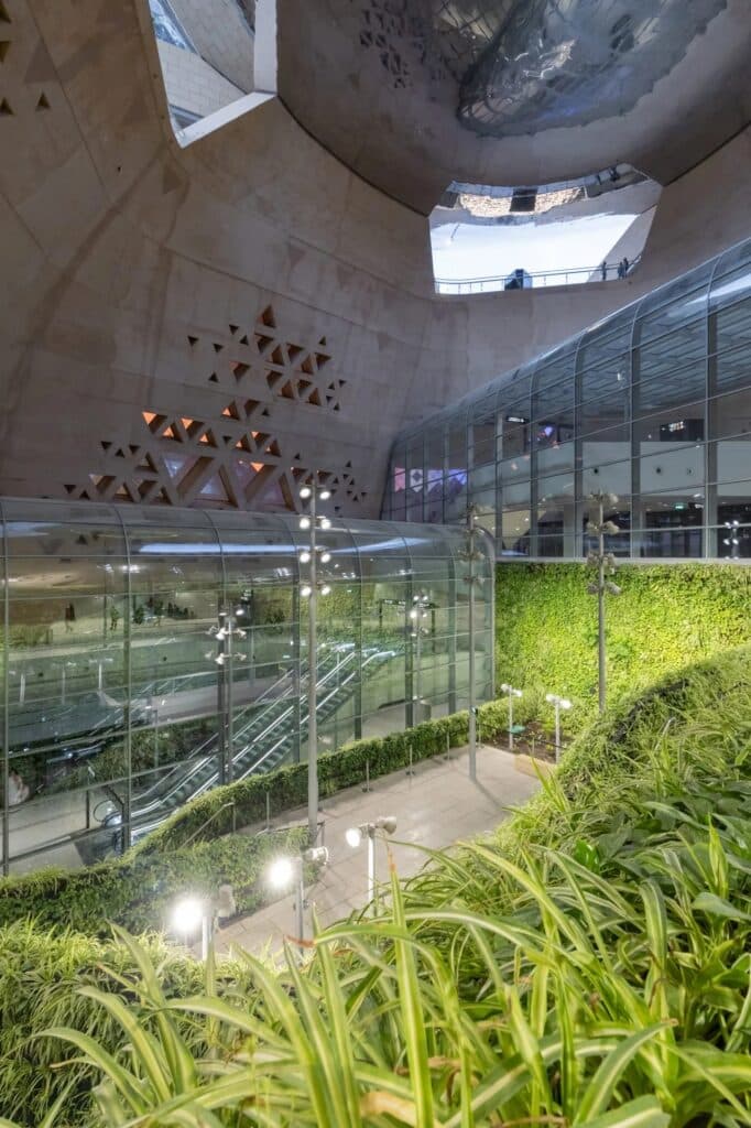 Subterranean green wall and indoor garden at Qasr Al-Hukm Metro Station with natural light filtering through the canopy.