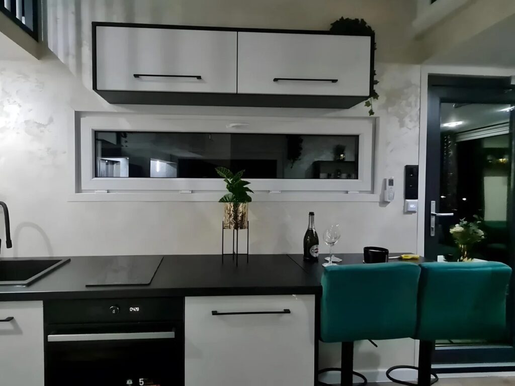 Modern compact kitchen in Erica tiny house with integrated appliances and breakfast bar.