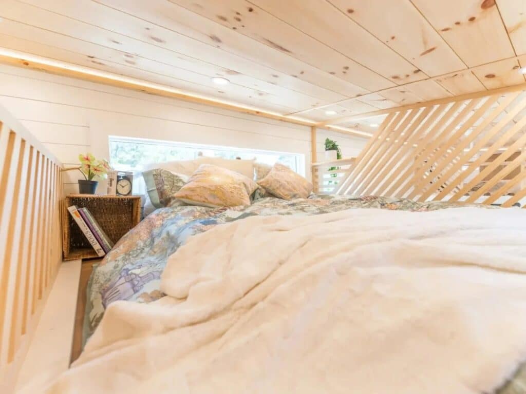 Close-up of the sleeping loft in Premium Vista with pine wood ceilings and a horizontal window.