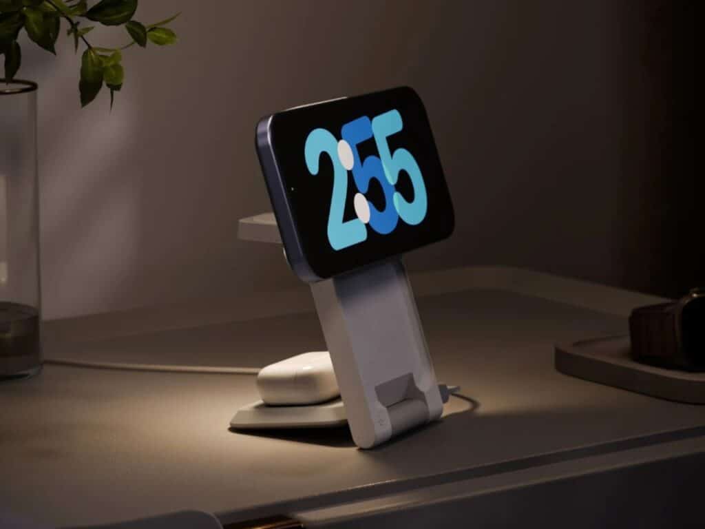 ARIA charging station at night with an iPhone in StandBy mode showing a large digital clock, softly illuminated by the built-in ambient light.