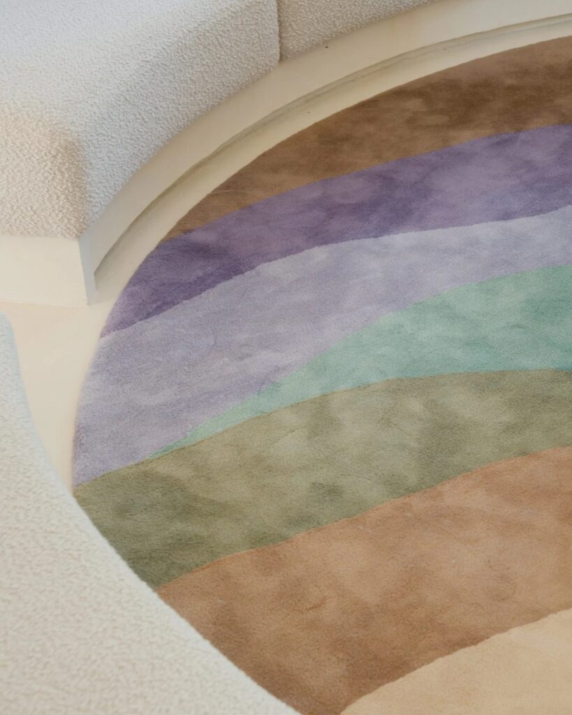 Top view of a colorful circular rug with wavy patterns inside the Seaside House conversation pit.