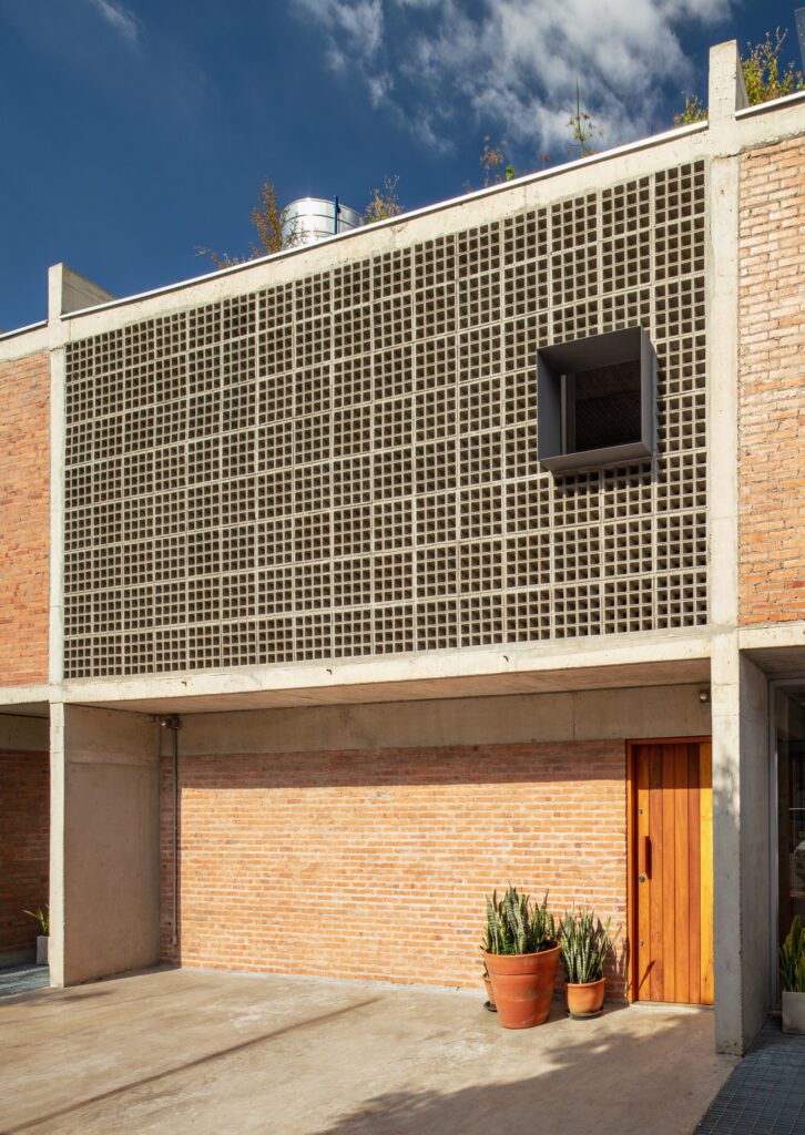Exterior detail of the concrete block wall and wooden entrance door of Caet&eacute;s House.