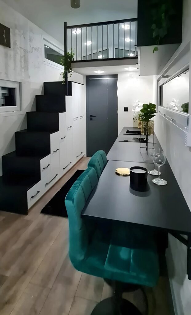 Longitudinal interior view of Erica tiny house showing the kitchen and stairs.