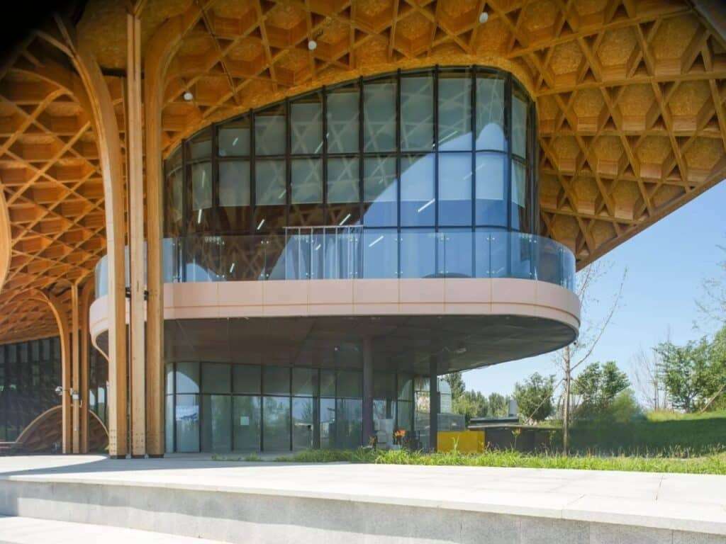 Close-up of the cantilevered glass balcony and the supporting glulam columns of the restaurant.