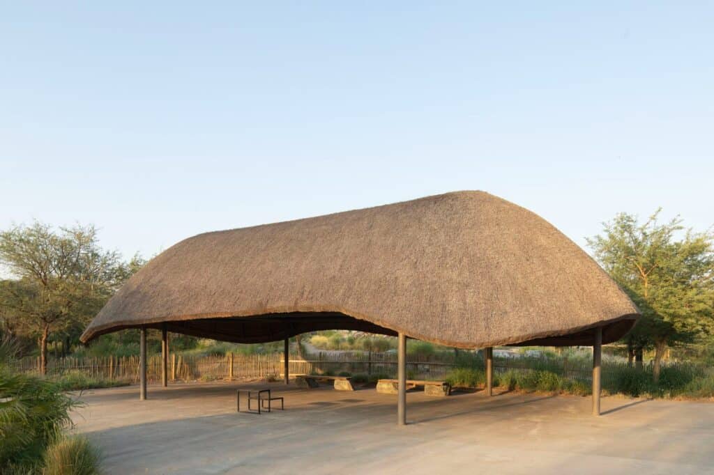 Open-air shaded classroom with a heavy thatched canopy in Sharjah Bridi Park.