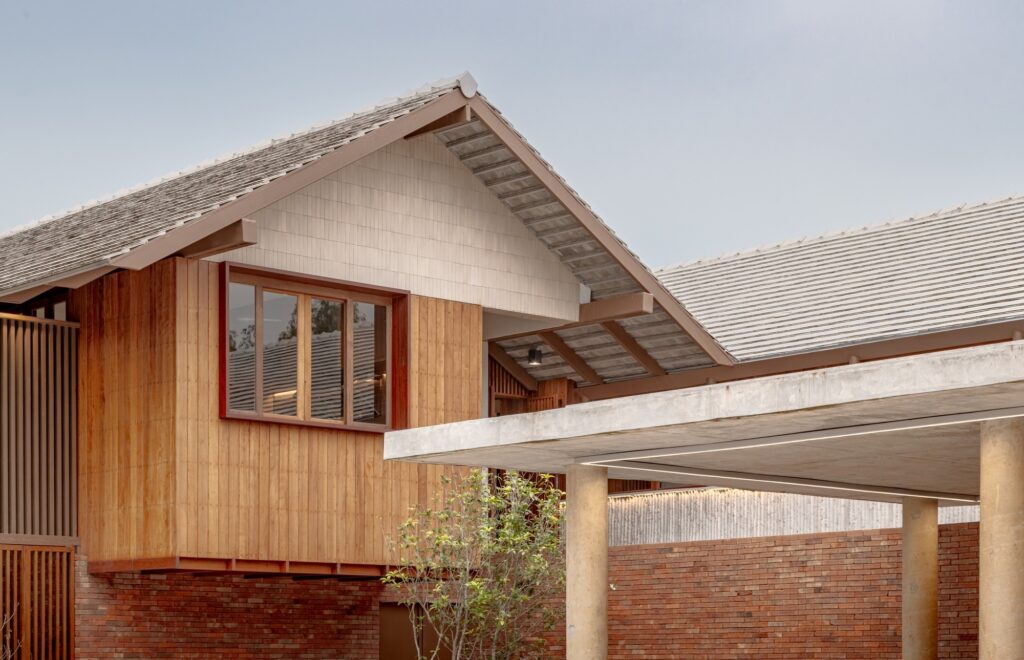 Close-up of the gabled roof and timber siding of the upper floor showing the "Double House" separation.