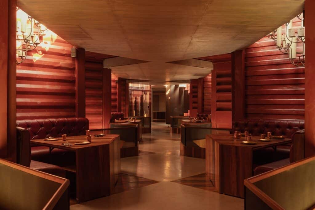 Symmetrical interior view of the dining area inside the shipping containers with red-painted corrugated walls.