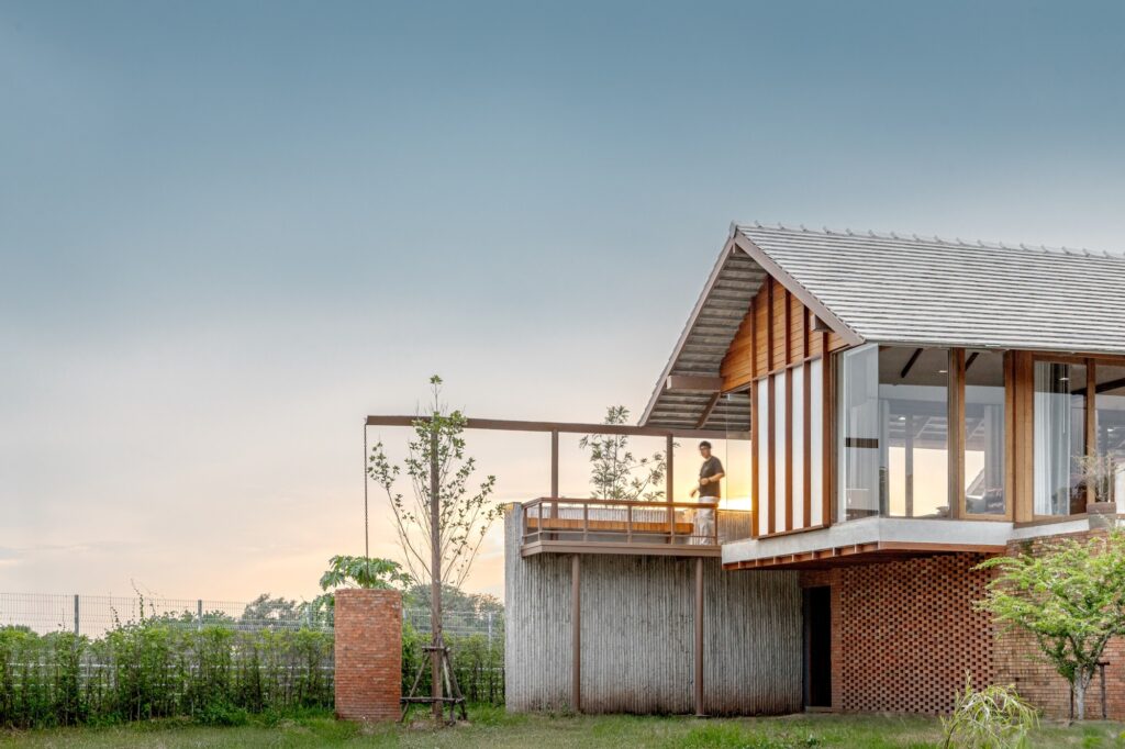 Exterior view of the house showing the rain harvesting system and brick water tanks at the north end.