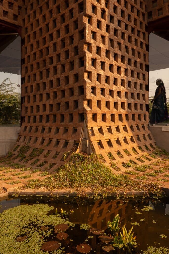 Extreme close-up of the perforated mud insulation on the container corner reflecting in a pond.