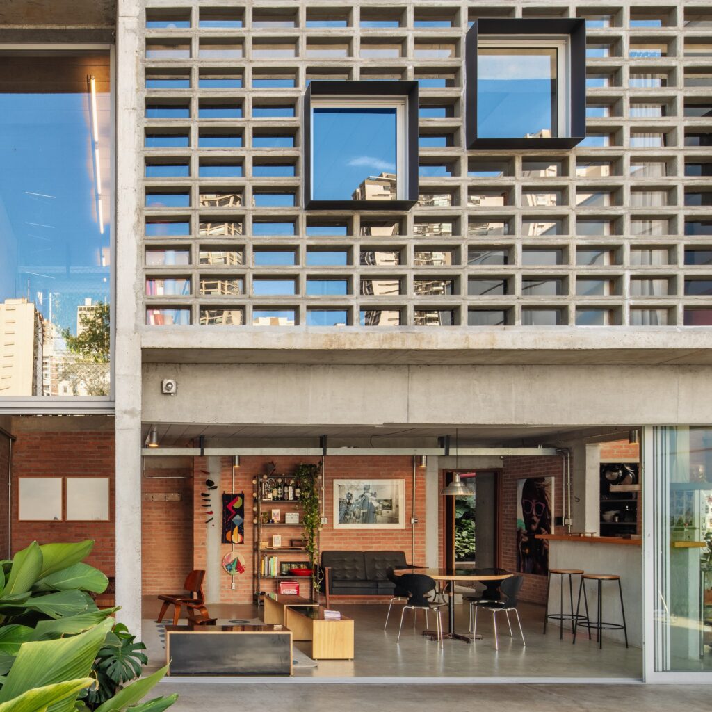 Ground floor social area viewed from the garden, showing the dining table and exposed brick interior.