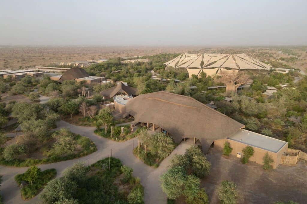 Aerial view of the Sharjah Bridi Park complex showing the distribution of thatched buildings in the desert.