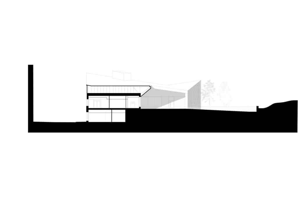 Architectural section of Postiljooni Daycare Centre showing the tiered levels and the relationship with the sloping hill.