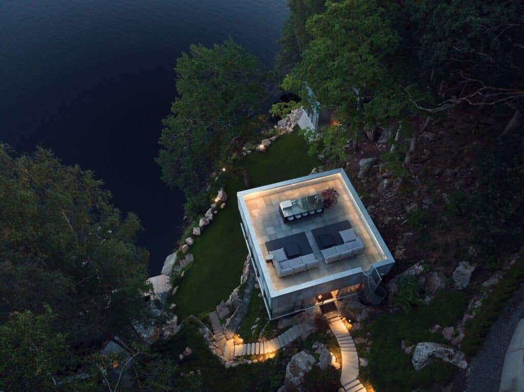 Aerial bird's-eye view of Bor&aring;s Getaway House rooftop terrace with outdoor furniture overlooking the lake and illuminated stone stairs.