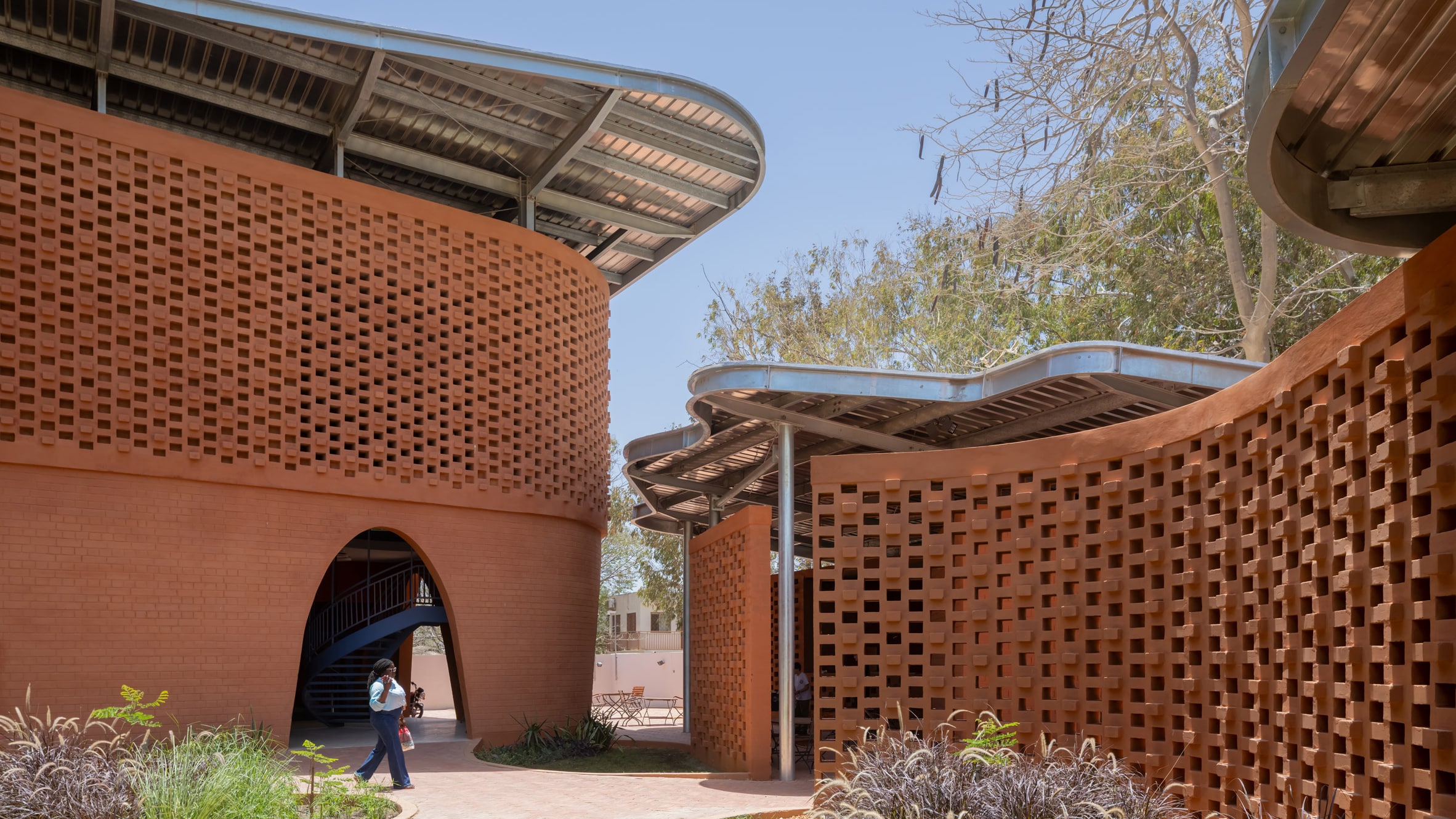 Goethe-Institut Dakar perforated earth brick facade with arched entrance and steel canopy
