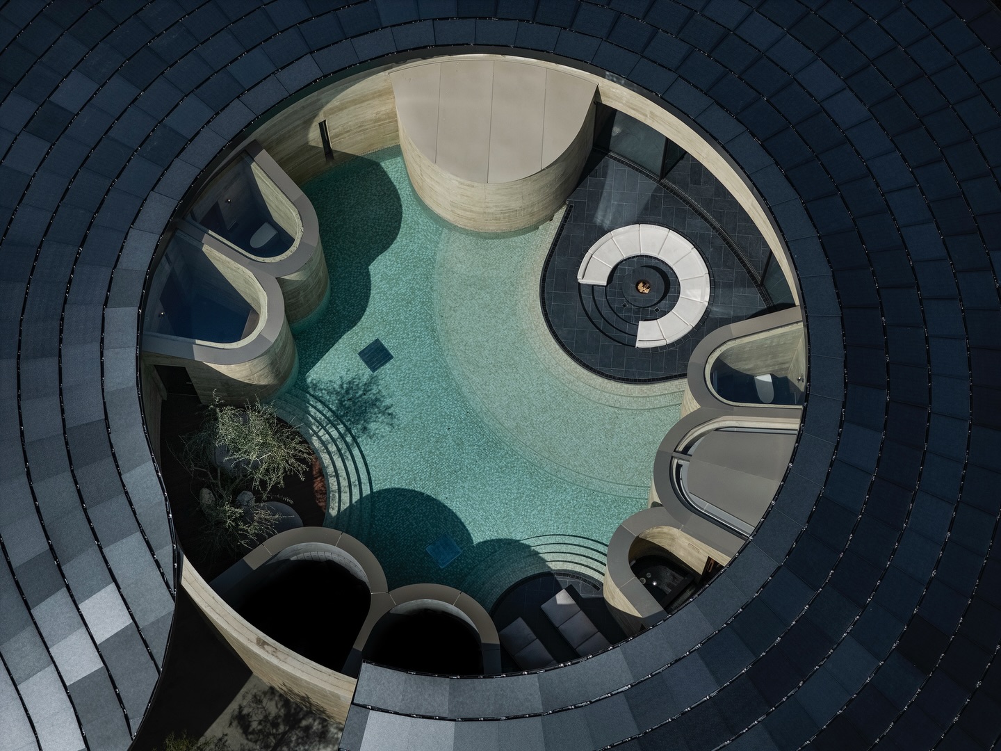 Interior of the rammed earth resort showing a curved glass wall, modern dining area, and panoramic views of the Seto Inland Sea.