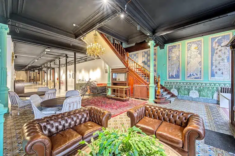 Ground floor interior of the historic Brussels factory showing patterned tiles and mint green columns