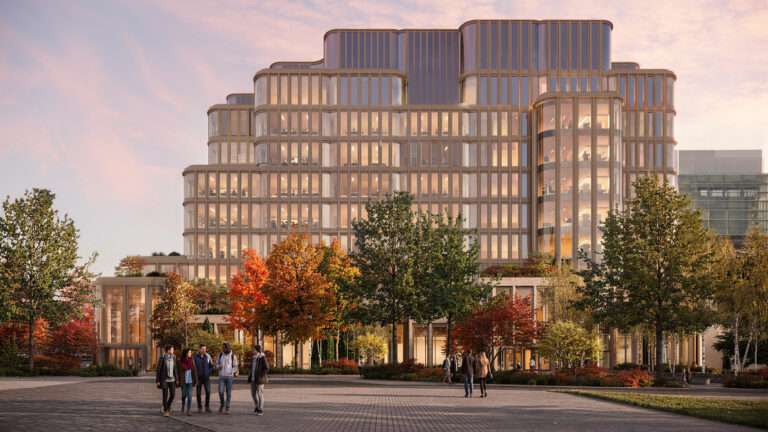 Triple-height hall inside the Temerty Building with students and timber columns.