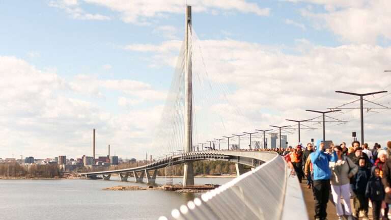 Kruunuvuori Bridge aerial view showing tram tracks and pedestrian crowds in Helsinki.