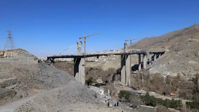 Partially collapsed concrete structure of the B1 Bridge with construction cranes visible