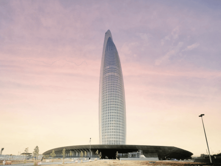 Mohammed VI Tower facade detail viewed from below showing vertical ribbed cladding and curved podium entrance in Rabat