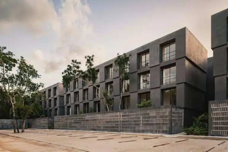 Concrete brise-soleil screens and preserved tropical trees in a courtyard at Casa Selva.