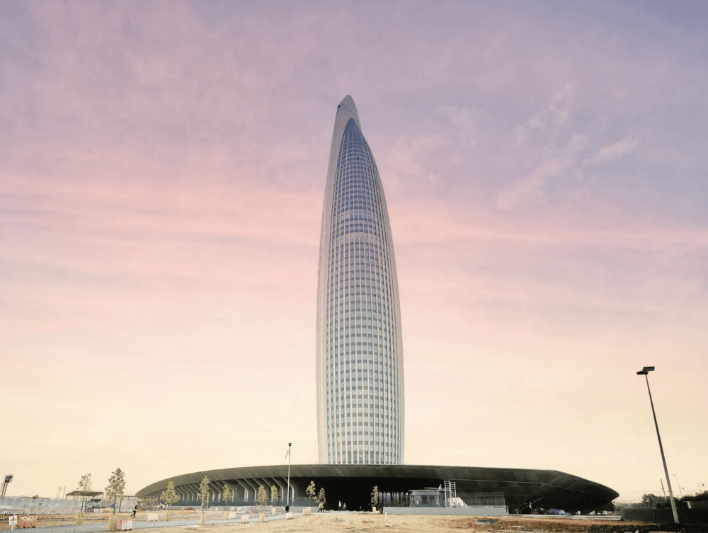 Mohammed VI Tower facade detail viewed from below showing vertical ribbed cladding and curved podium entrance in Rabat
