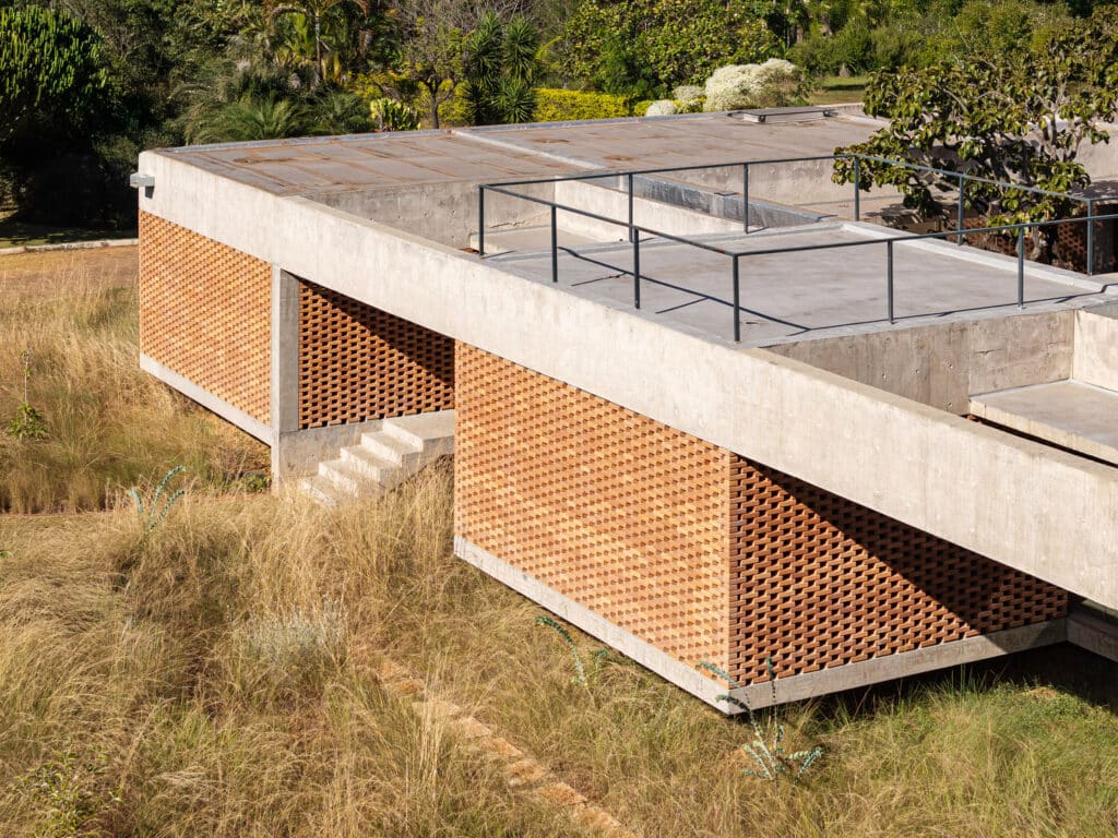Elevated concrete and brick structure of Casa Tupin raised on pillars above Cerrado vegetation