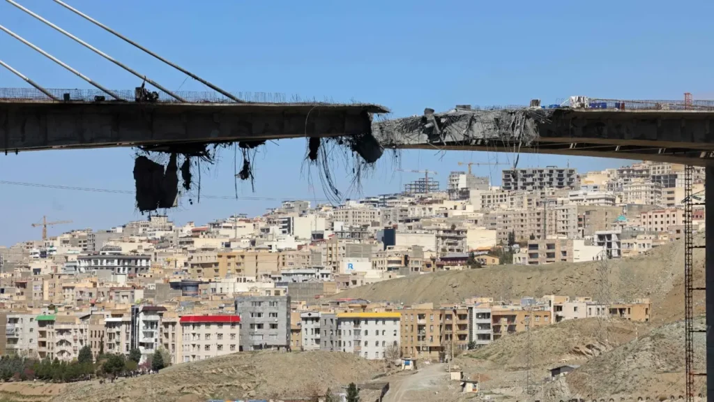 A massive gap in the B1 Bridge deck overlooking the dense urban landscape of Tehran